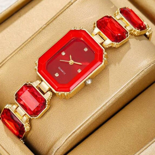 Red and gold watch on a beige cushioned surface