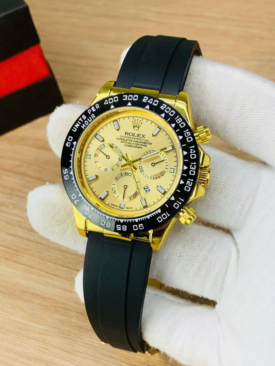 Gold watch with black strap on a wooden surface