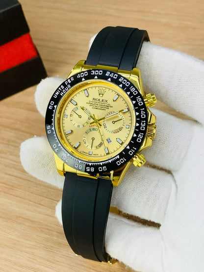 Gold watch with black strap on a wooden surface