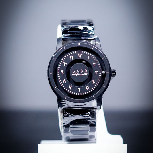 Watch with black face and silver band on a gray background