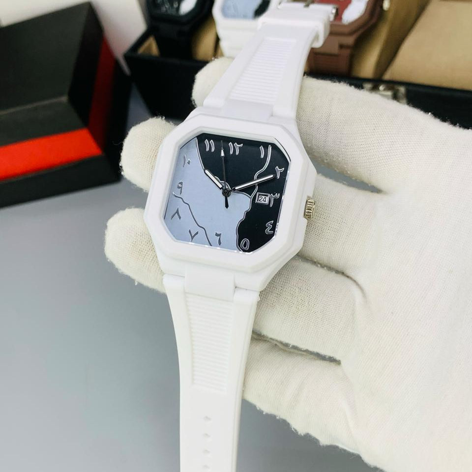 White watch with a unique design held by a gloved hand on a gray surface.