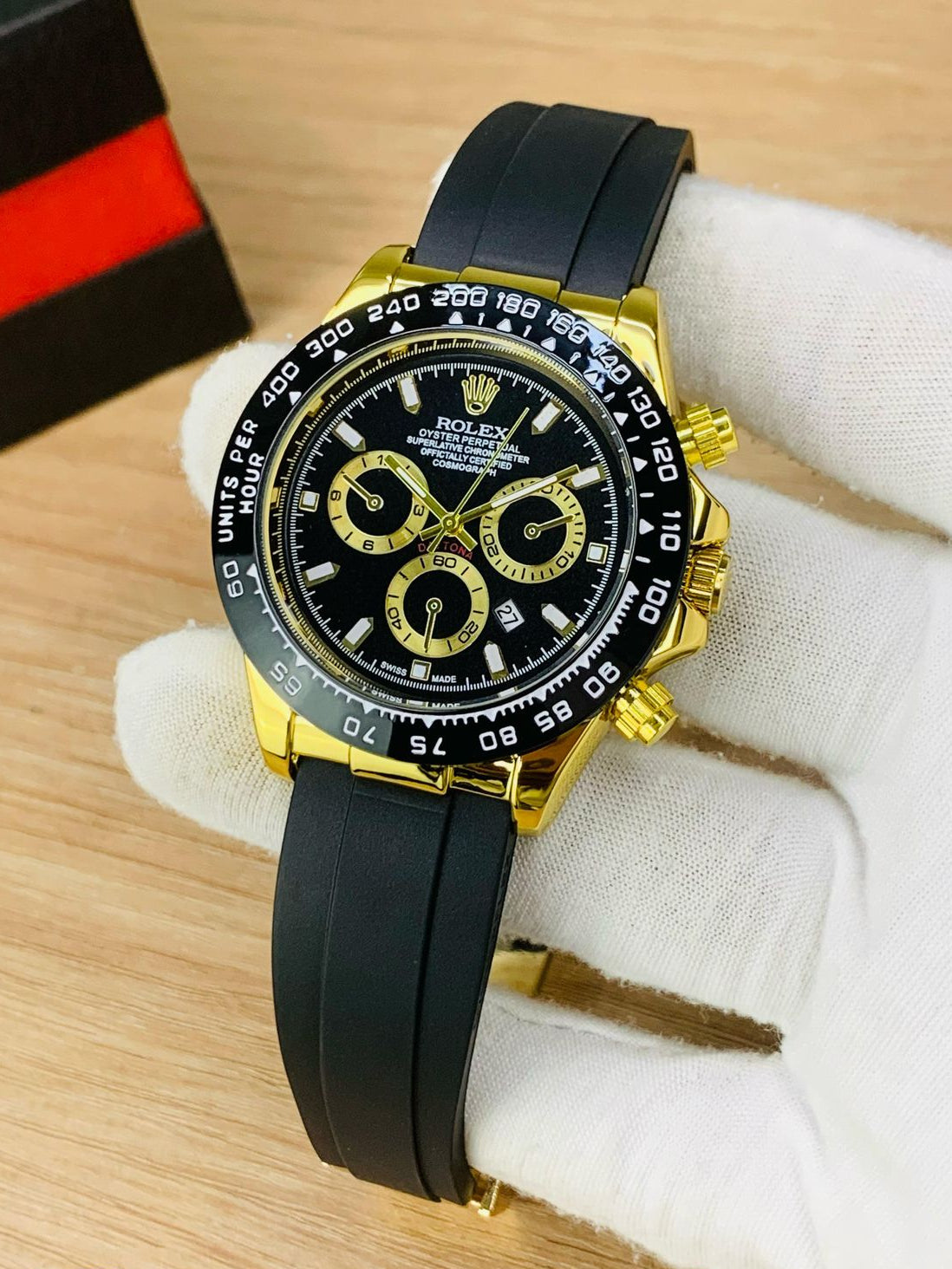 Luxury watch with black and gold design on a wooden surface