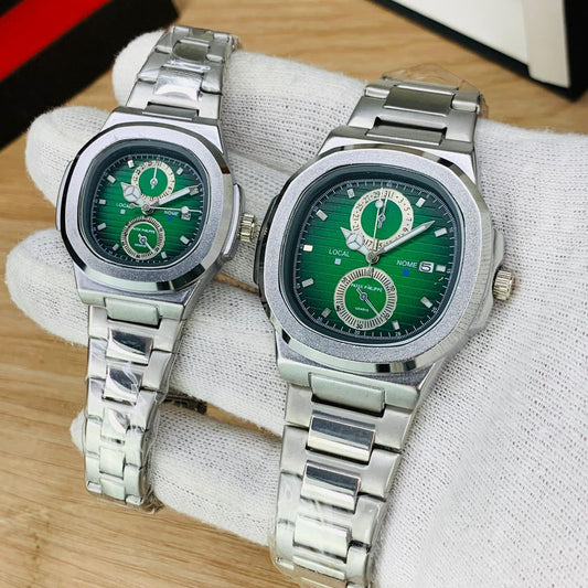 Two silver watches with green faces on a white cloth background
